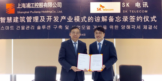 SK텔레콤은 건물 내 인원의 안전과 시설을 관제하는 건물 통합관리 솔루션을 중국 상하이 대형 시설관리 기업 '상하이 푸장 홀딩스(SPH)'에 제공하기로 협약(MOU)을 체결했다고 9일 밝혔다. 차인혁 SK텔레콤 IoT사업본부장(오른쪽)이 샤오싱타오 상하이푸장홀딩스대표와 협약을 맺고 기념촬영을 하고 있다. <SK텔레콤 제공>